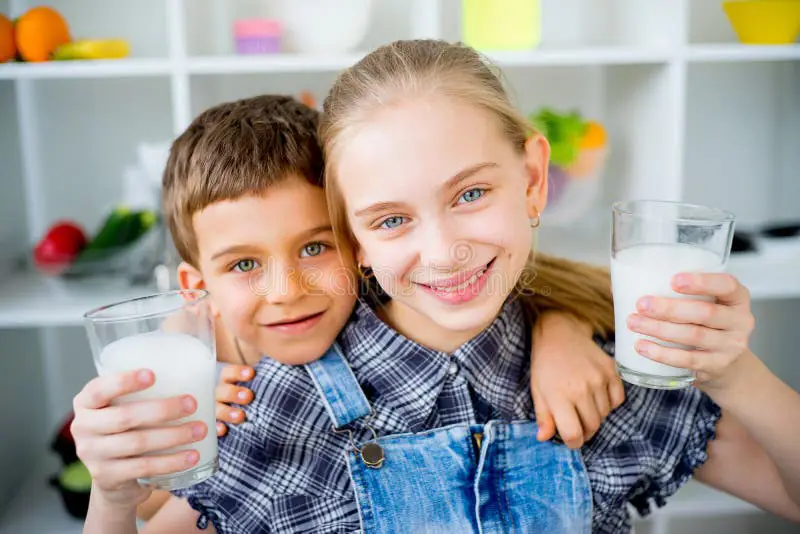 Anak bahagia sedang minum susu