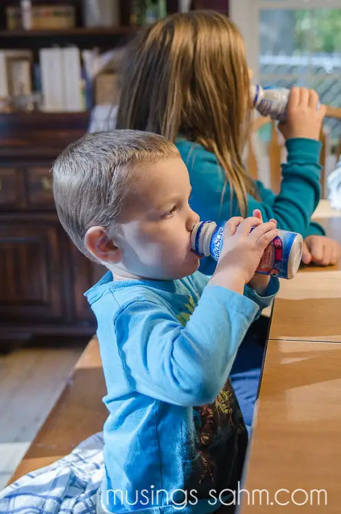 Gambar anak yang bahagia sedang minum Pediasure.