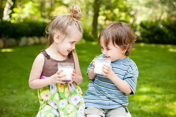 Anak yang gembira sedang minum susu