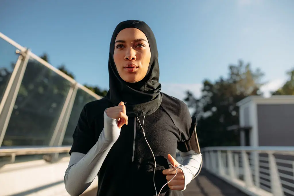 Model sedang mempromosikan baju gym wanita hijab