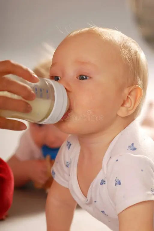 Bayi yang bahagia sedang minum susu