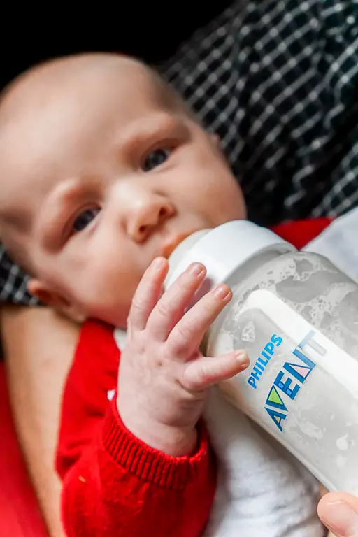 Bayi sedang minum susu dari botol susu Avent.