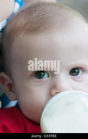 Bayi yang sedang minum susu dengan gembira