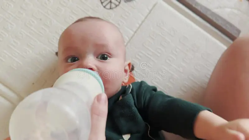 Bayi yang gembira sedang minum susu