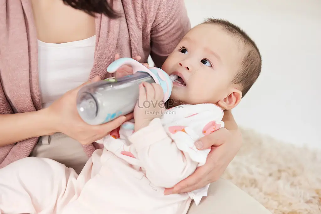 Gambar bayi yang sedang minum susu formula dengan gembira.