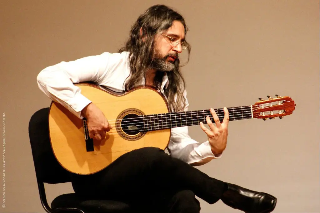 Seorang pemain gitar flamenco sedang memainkan gitarnya