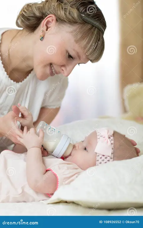 Ibu memberi makan bayi dengan botol susu formula