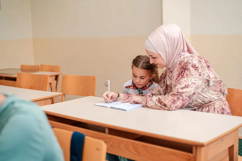 Guru perempuan berhijab mengajar di kelas