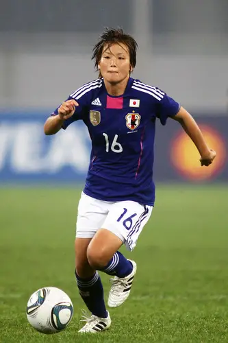 Seorang pemain sepak bola wanita Jepang sedang beraksi di lapangan.