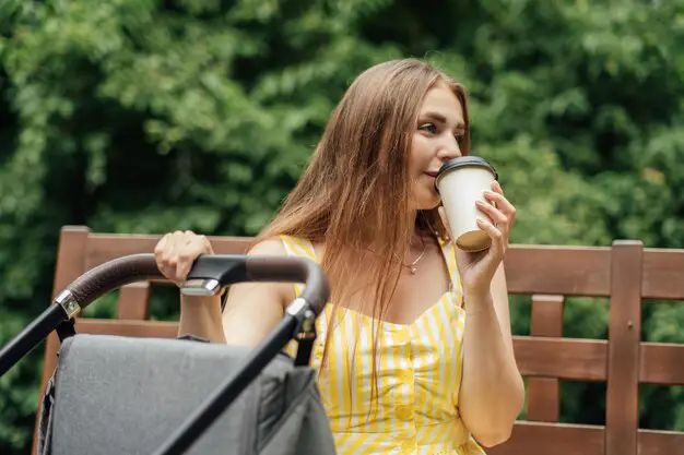 Ibu menyusui sambil menikmati secangkir kopi