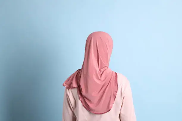 Wanita berhijab dari belakang dengan gaya yang anggun dan sederhana.