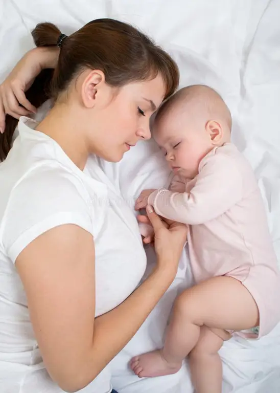 Ibu dan bayi yang bahagia tidur bersama