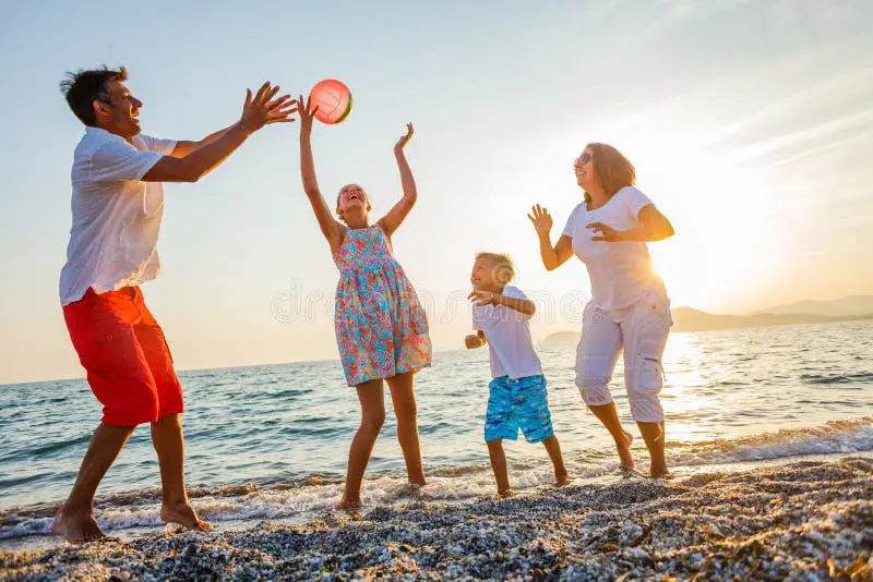 Gambar keluarga bermain di pantai