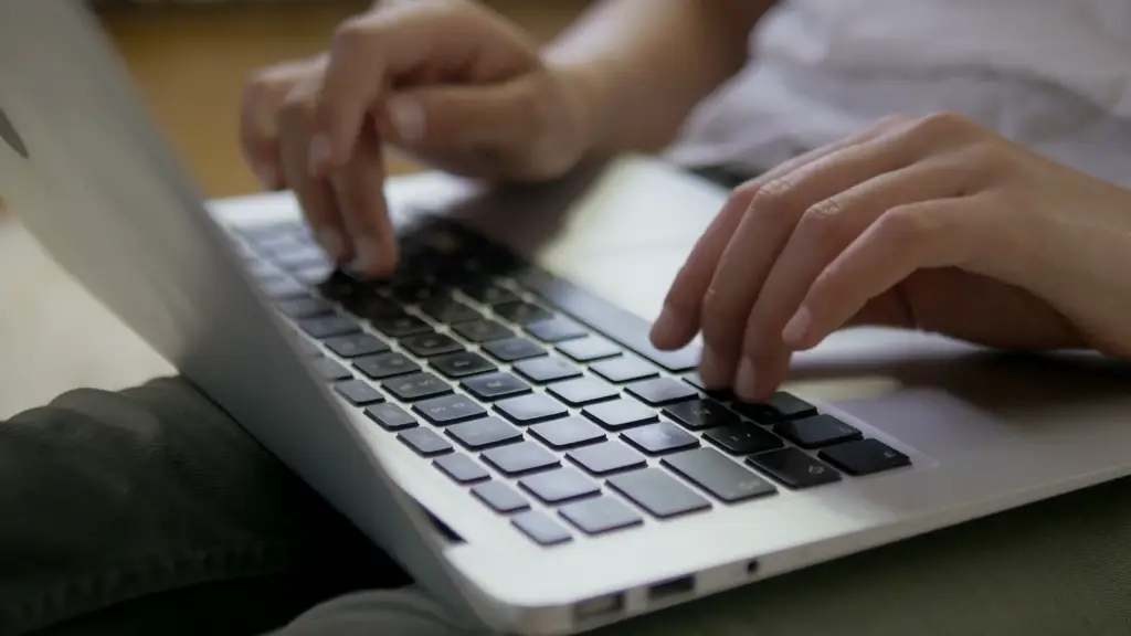 Sebuah gambar close-up tangan seseorang yang mengetik di keyboard