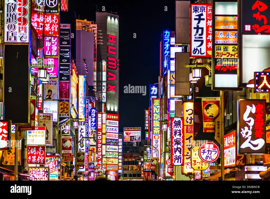 Suasana kota Jepang di malam hari yang ramai dan penuh cahaya.