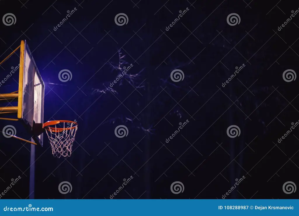 Lapangan basket malam hari yang diterangi lampu