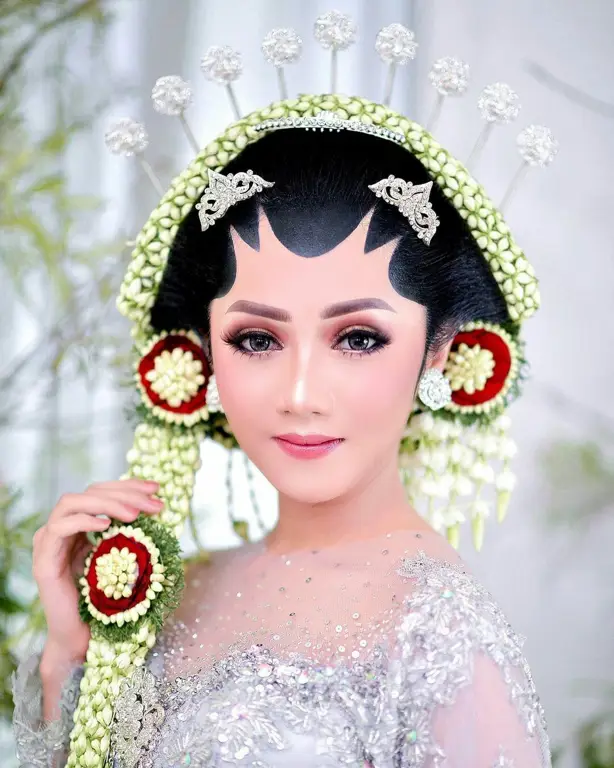 Pengantin Jawa dengan riasan paes dan hijab