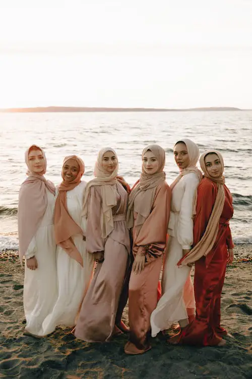 Siluet wanita berhijab menikmati sunset di pantai