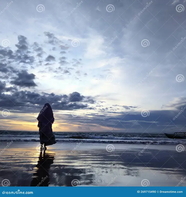 Potret wanita berhijab cantik di pantai saat matahari terbenam