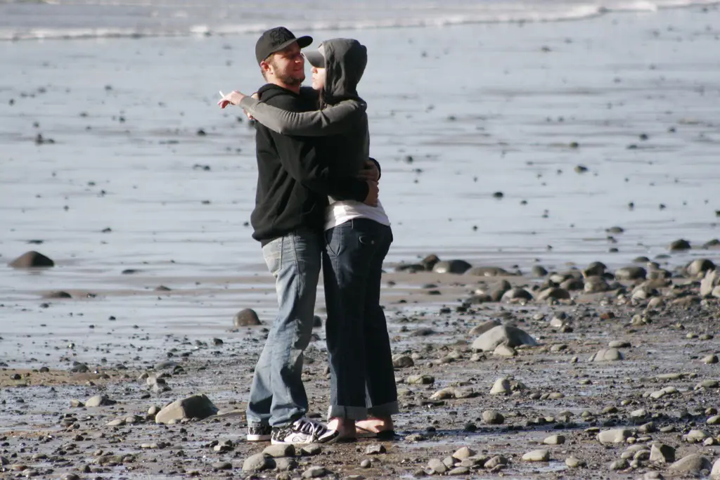 Pasangan bermesraan di pantai yang sepi