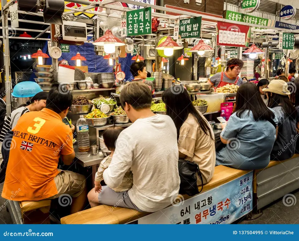 Sejumlah orang Korea sedang menikmati makanan bersama dengan ekspresi bahagia.