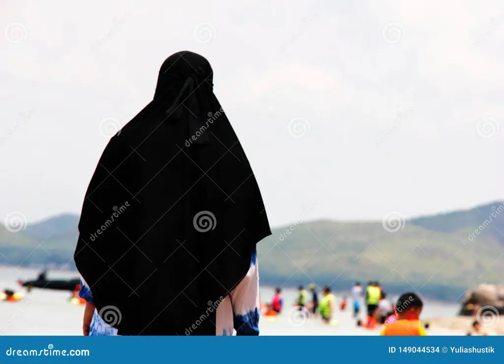 Wanita berhijab menikmati waktu di pantai