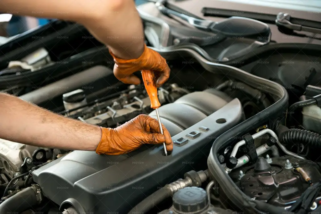 Mekanik mobil sedang memperbaiki mesin