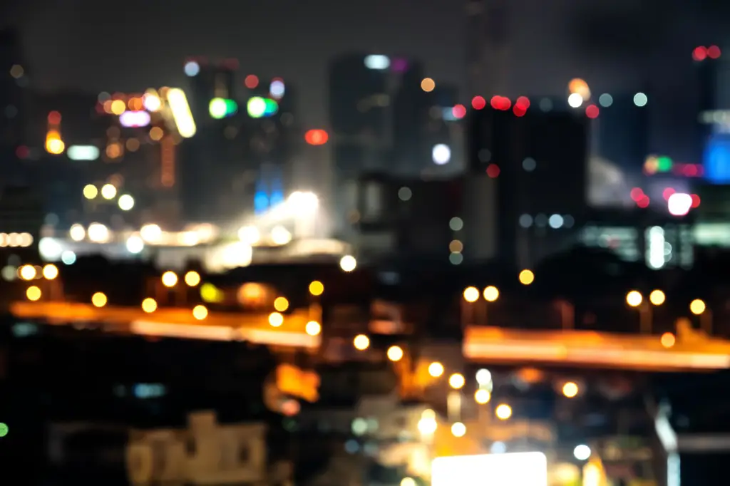 Foto pemandangan kota malam dengan efek line bokeh yang dramatis.