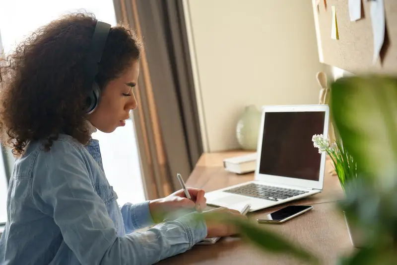 Gambar seorang mahasiswa yang sedang menggunakan laptop