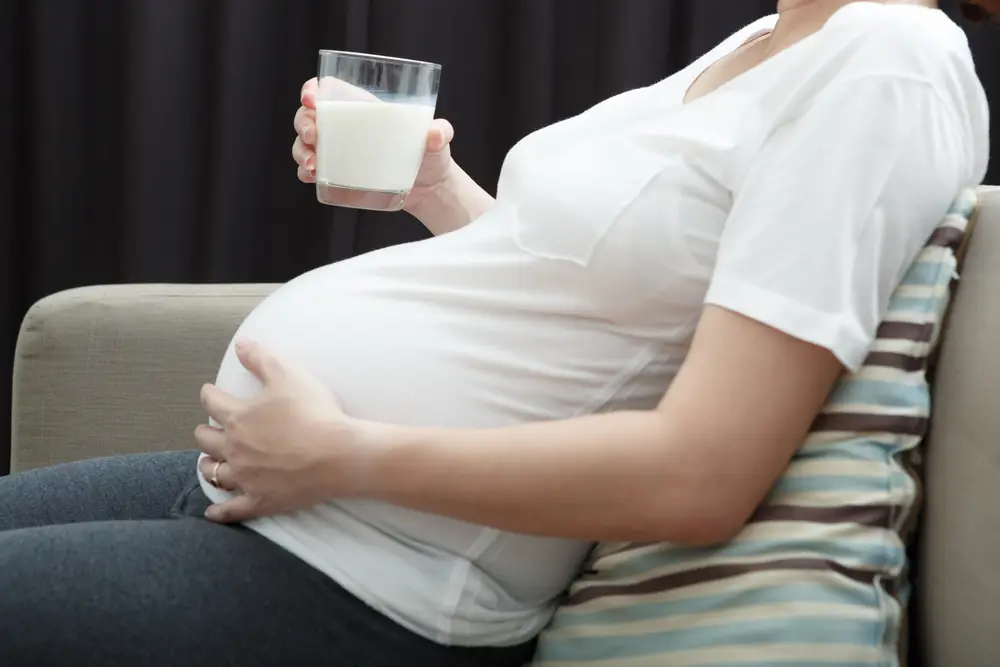 Wanita hamil sedang minum susu