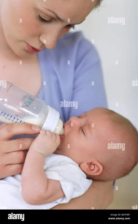 Ibu sedang memberi makan bayi dengan botol susu