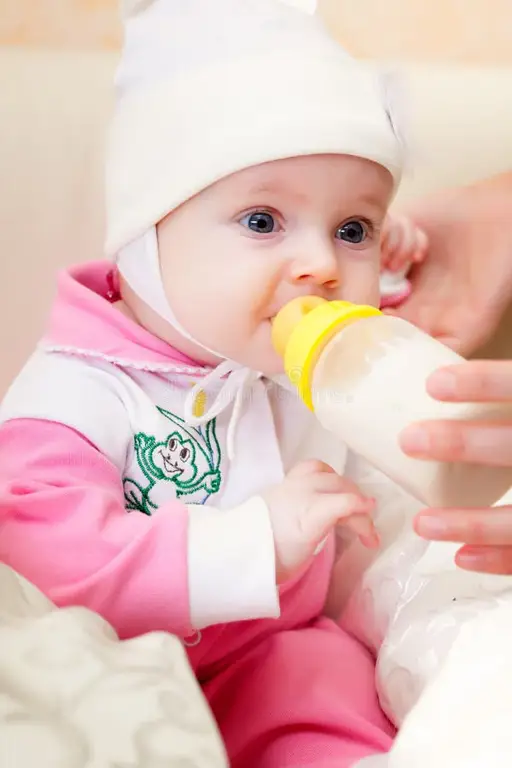 Bayi sedang minum susu dari botol