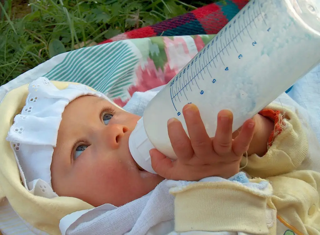 Bayi sedang minum susu dari sachet