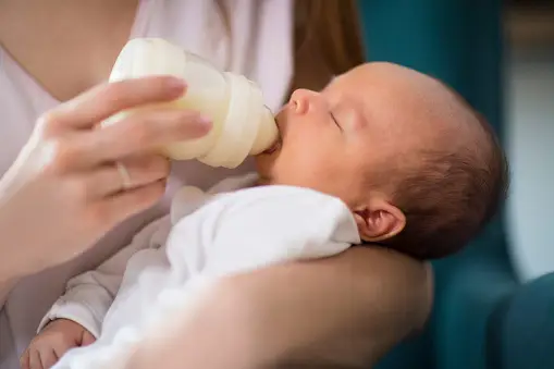 Ibu memberi makan bayi dengan botol susu