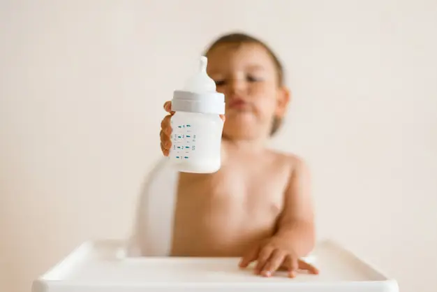 Bayi sedang minum susu dari botol