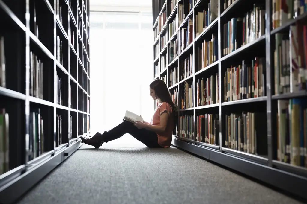 Seseorang sedang membaca buku di perpustakaan