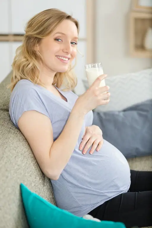 Seorang wanita hamil sedang minum susu