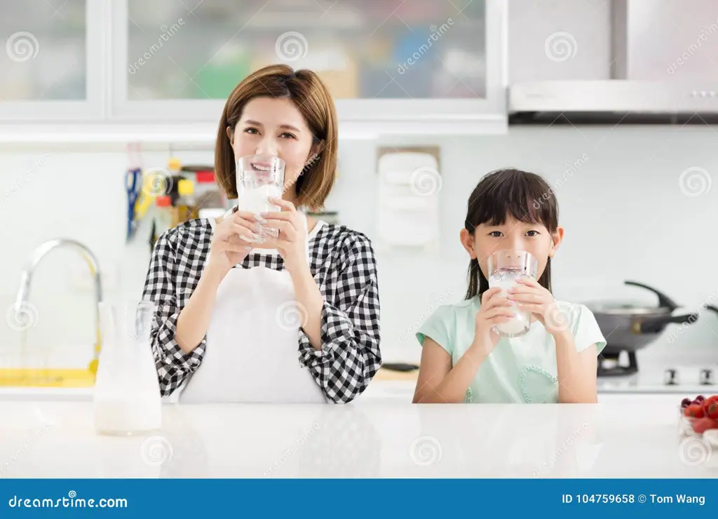 Ibu dan anak sedang menikmati susu bubuk kotak