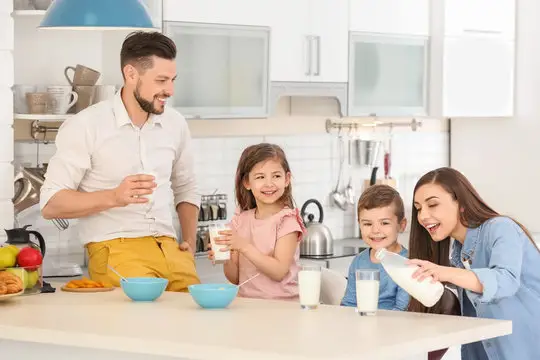 Keluarga bahagia sedang minum susu bersama