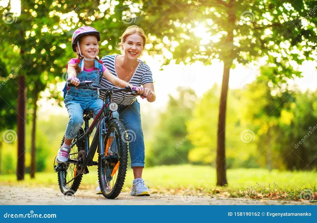 Ibu dan anak bersepeda di jalur taman