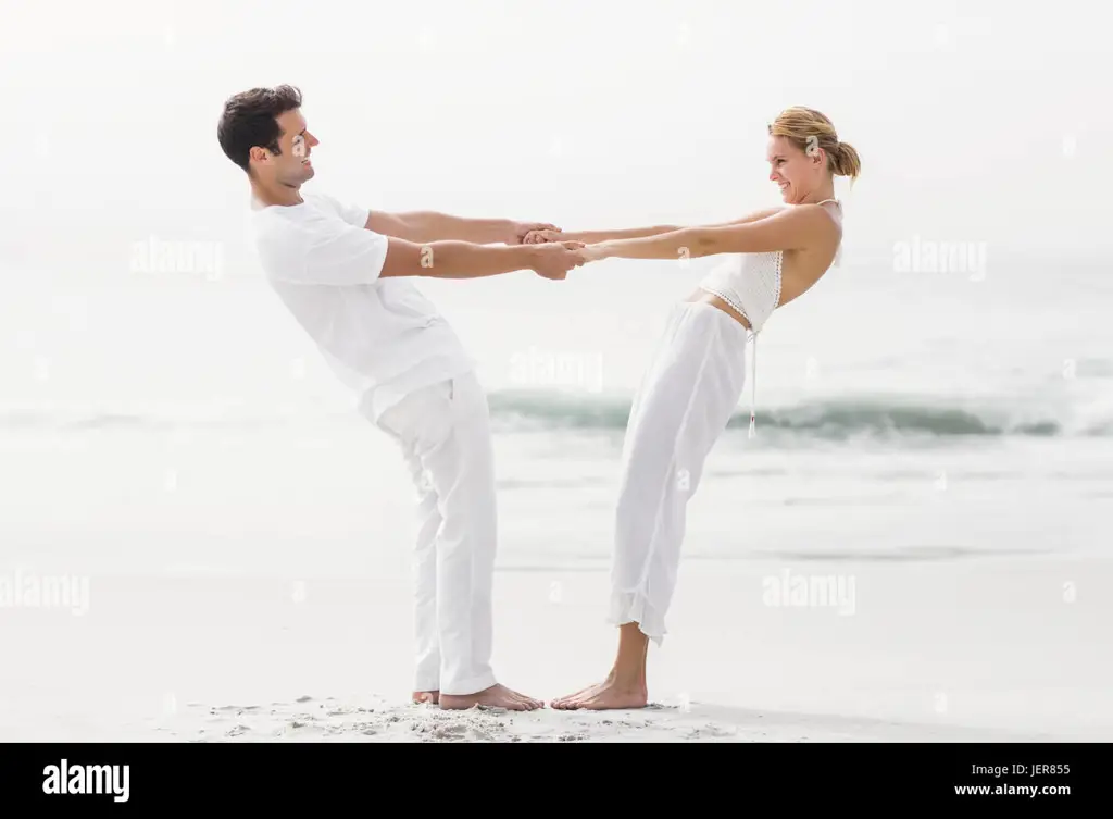 Pasangan romantis bergandengan tangan di pantai