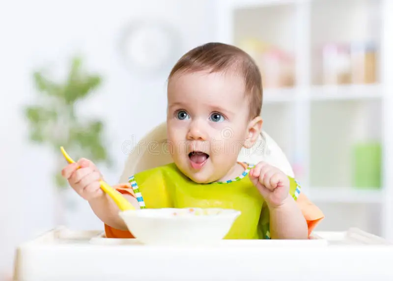 Gambar bayi yang sehat dan gembira sedang makan makanan sehat