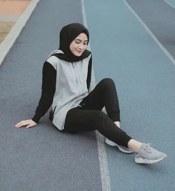 Wanita berhijab dengan outfit sporty saat mendaki gunung