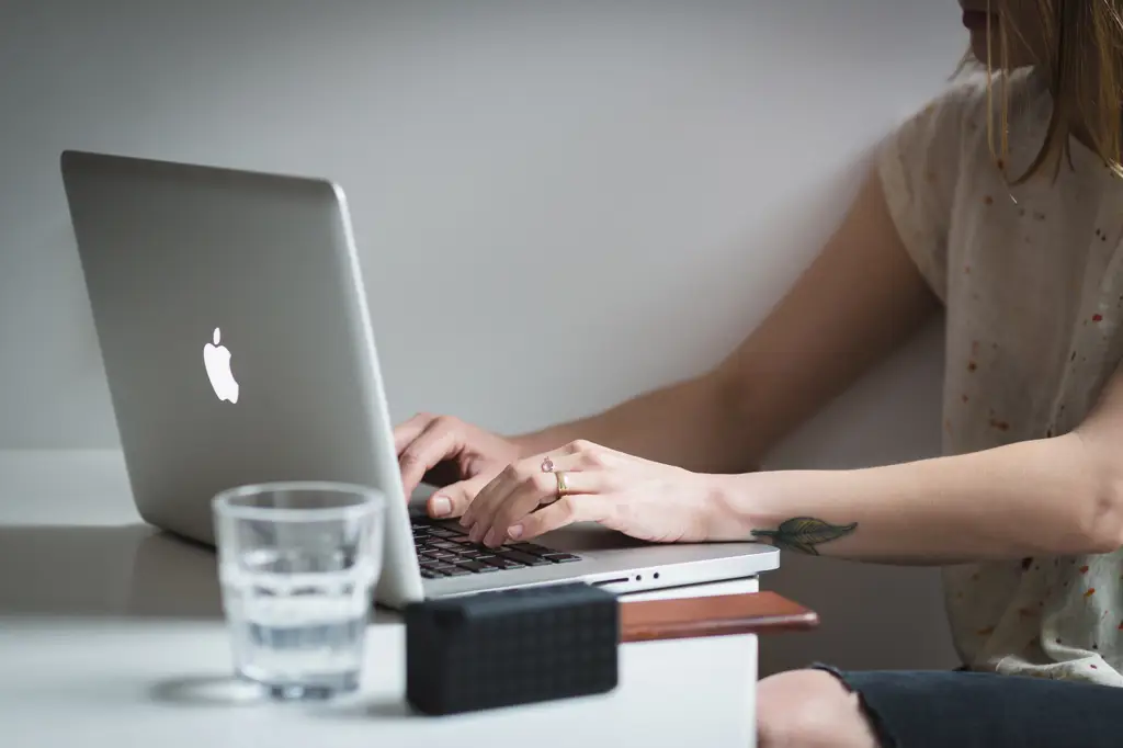 Seorang wanita sedang menggunakan Twitter di laptopnya