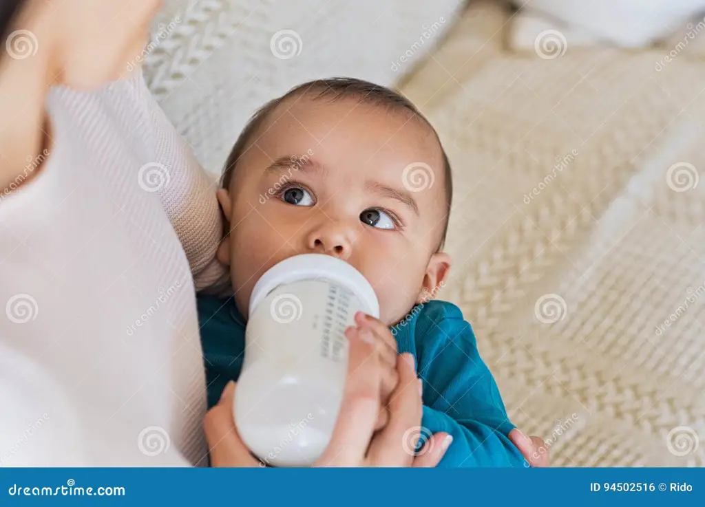 Orang tua mengawasi anak minum susu dari pouch