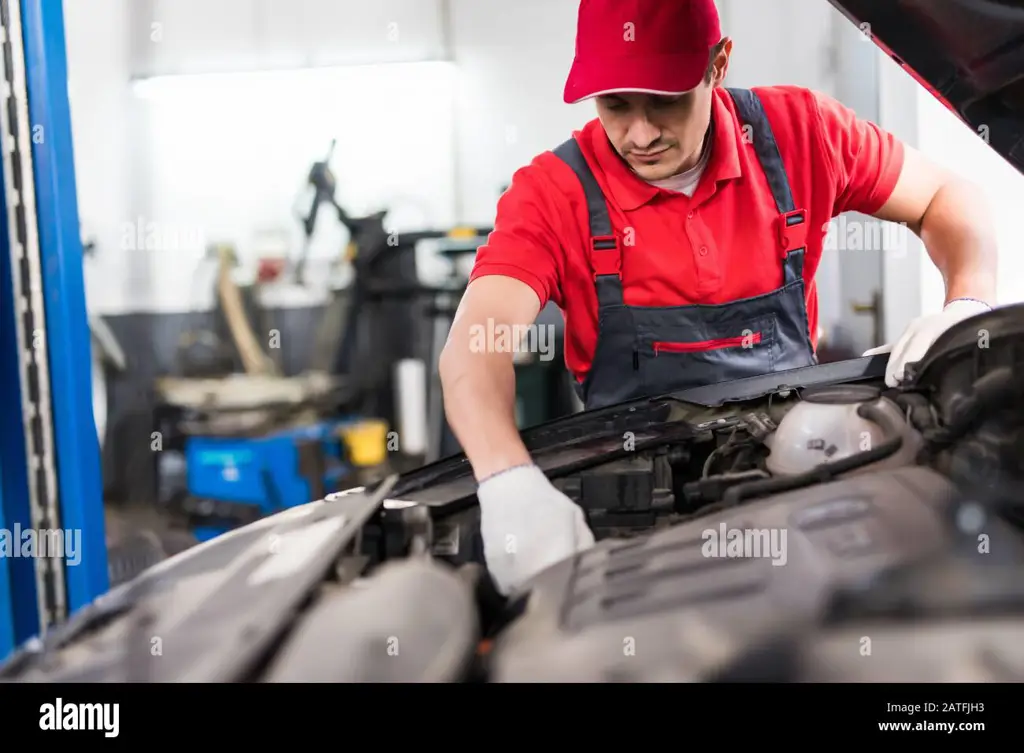 Gambar mekanik sedang memperbaiki mesin mobil