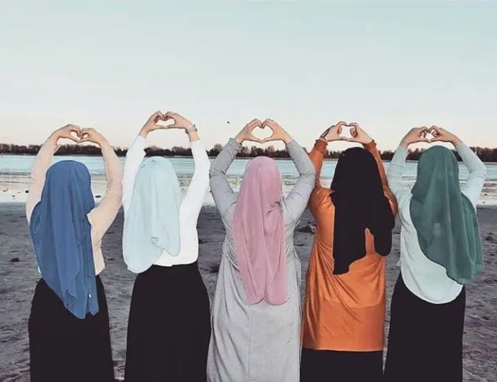 Empat wanita berhijab berpose kasual dengan latar belakang yang indah