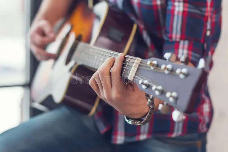 Kadet tangan sedang memainkan kunci gitar