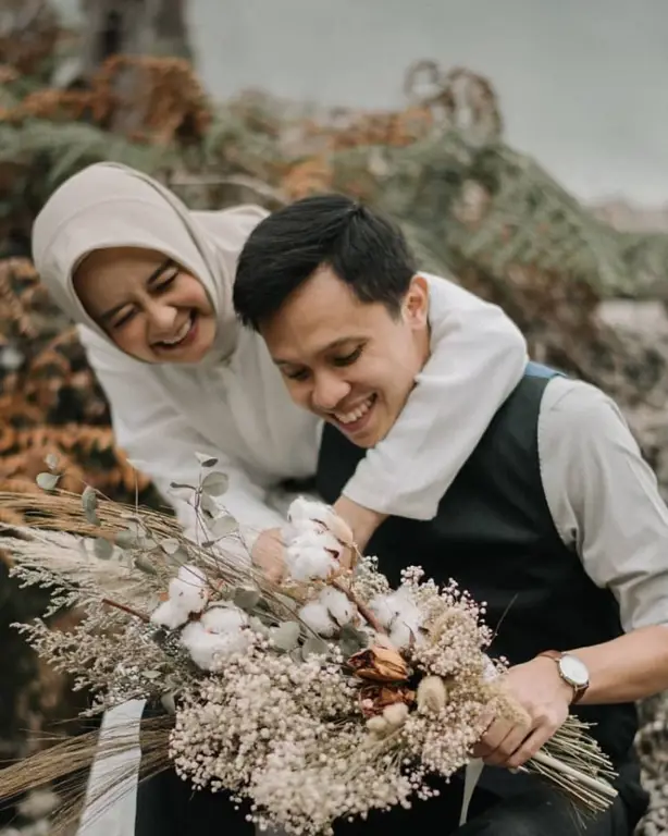 Foto prewedding hijab kasual di studio dengan bunga