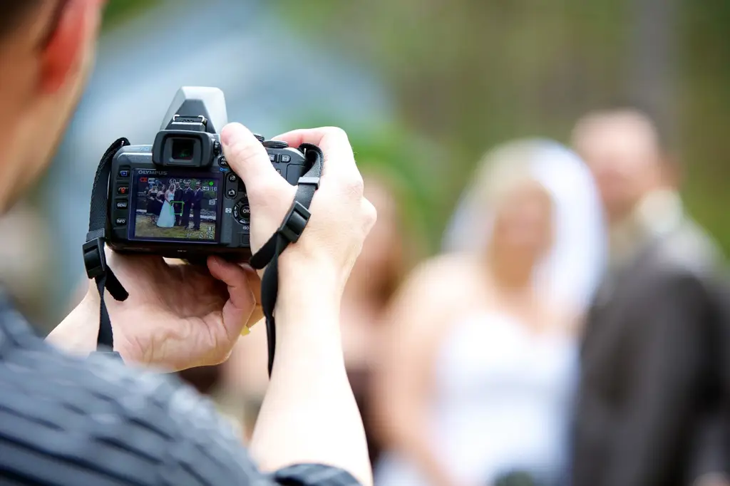 Fotografer pernikahan sedang mengambil gambar pasangan pengantin.